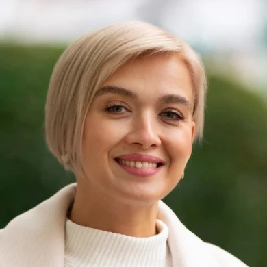 Надежда Любимова улыбается на фоне зелени